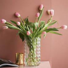 Load image into Gallery viewer, Zayla Bubble Vase by Allthingscurated features a geometric bubble design. The eye-catching detail and design are enough to make it a statement centerpiece with or without floral display. Comes in black or clear and in 2 sizes. The short vase measures 17cm or 6.6 inches in height and 16cm or 6.2 inches in diameter. The tall vase measures 27.5cm or 10.7 inches in height and 13cm or 5 inches in diameter. This is a clear tall vase with a bunch of pink tulips.