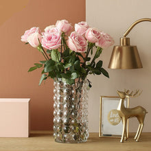 Load image into Gallery viewer, Zayla Bubble Vase by Allthingscurated features a geometric bubble design. The eye-catching detail and design are enough to make it a statement centerpiece with or without floral display. Comes in black or clear and in 2 sizes. The short vase measures 17cm or 6.6 inches in height and 16cm or 6.2 inches in diameter. The tall vase measures 27.5cm or 10.7 inches in height and 13cm or 5 inches in diameter. This is a tall clear vase with a bunch of pink roses.