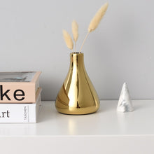 Load image into Gallery viewer, Solo gold mini vase between a stack of books and a mini ceramic tree.