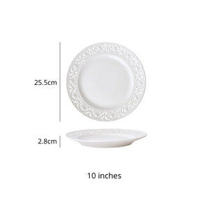 Juliette White Lace Dinnerware by Allthingscurated adds an elegant touch to your tabletop. This sophisticated set is crafted out of ceramic with a beautiful embossed lace rim, giving it a vintage touch.  The creamy white pieces come in a dinner plate and cake stand in 2 sizes for easy mixing and matching. They are perfectly sized for a main course, starters and desserts. Featured here is a 10 inches or 25.5cm plate.
