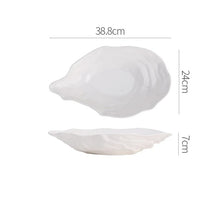 Load image into Gallery viewer, Oyster Shape Serving Dish by Allthingscurated is elegantly crafted in pristine white ceramic to mirror the contours and texture of the elegant oyster. The striking serve ware comes in multiple sizes for plating appetizers or main courses. Seen here is the 38.8cm or 15.25 inches oyster dish.
