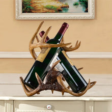 Load image into Gallery viewer, Antler Wine Bottle Holder by Allthingscurated is hand-crafted from resin and hand-painted to emulate the look of genuine antlers. Beautiful and sculptural, it’s a great gift for any occasion as well as a perfect addition to give your winter tablescape a cabin vibe. On its own, it’s a decorative, ornamental piece that gives a luxurious look to your mantel, tabletop or shelf. Measuring approximately 33cm or 13 inches in height, 35cm or 13.7 inches wide and a depth of 23cm or 9 inches.
