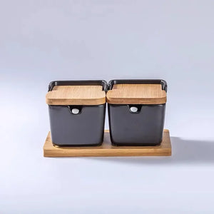 Ceramic Seasoning Storage Jars by Allthingscurated are the perfect storage solution to keep your herbs, seasonings and spices. Made of durable ceramic with a sustainable bamboo flip lid for easy access during cooking. These jars are not only functional but also environmentally friendly. Comes with a bamboo tray and ceramic spoons. Featured here is a set of 2 black jars with spoons and tray.