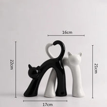 Load image into Gallery viewer, These Cat Couple Love Figurines by Allthingscurated are perfect for cat lovers. Made of ceramic, they feature a pair of cute and whimsical cats in contrasting colors, with their tails entwined to form a heart shape. A romantic and unique gift for any occasion. This set features a pair of black and white cats.
