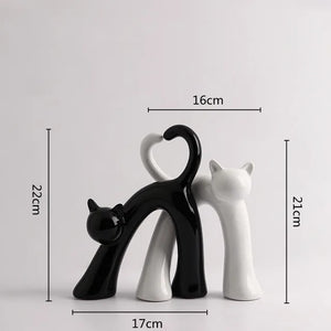These Cat Couple Love Figurines by Allthingscurated are perfect for cat lovers. Made of ceramic, they feature a pair of cute and whimsical cats in contrasting colors, with their tails entwined to form a heart shape. A romantic and unique gift for any occasion. This set features a pair of black and white cats.