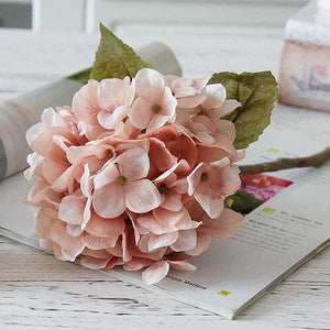 Silk Hydrangeas by Allthingscurated are made of premium quality silk that feature realistic looking flowers that are perfect for home décor and wedding venue decoration. Create a stunning display with 8 lovely colors available and add a touch of beauty and elegance to any space.  Featured here is the color Blush Pink.