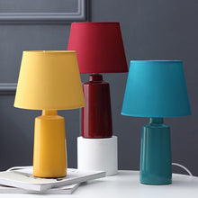 Load image into Gallery viewer, Burano Table Lamp by Allthingsucrated comes in 3 gorgeous colors in Red, Blue and Yellow.  The lamp base is made of ceramic and the lampshade of fabric.  Both the base and lampshade are of the same color.
