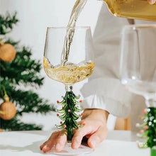 Load image into Gallery viewer, Wine glass with a Christmas tree design being filled with white wine, with a blurred background. These charming Christmas Tree Stem Glass by Allthingscurated features a sculptural 3D design on the stem. Comes in classic green or bright white, it adds a festive vibe to your holiday gatherings. These glasses make thoughtful gifts for your loved ones.
