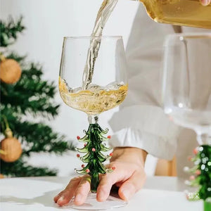Wine glass with a Christmas tree design being filled with white wine, with a blurred background. These charming Christmas Tree Stem Glass by Allthingscurated features a sculptural 3D design on the stem. Comes in classic green or bright white, it adds a festive vibe to your holiday gatherings. These glasses make thoughtful gifts for your loved ones.