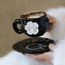 Load image into Gallery viewer, This Camellia Porcelain Cup Set / Mug by Allthingscurated features a single, significant bloom in a timeless black and white design that exudes sophistication. Its high fashion appeal makes it a perfect gift or impressive addition to your high-tea gatherings. Available as a mug or a cup set.
