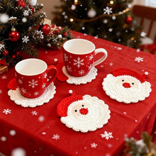 Load image into Gallery viewer, Red and white Santa Claus design crochet coasters with two red and white snowflake design mugs on a table, decorated with red and white table cloth in snowflake design.

