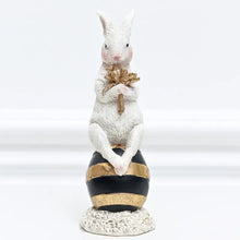 Load image into Gallery viewer, Our Regal Rabbit Family Figurines by Allthingscurated are beautifully-crafted and decorative. Made high-quality resin, these unique figurines will add a touch of elegance and whimsy to your home décor. Available in 6 designs, they are the perfect additions to your spring and Easter decorations. Featured here is Egg Sitting Rabbit.
