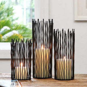Estel Black Wire Candle Holders by Allthingscurated have openwork pattern that resembles willow-like branches in a cylindrical arrangement.  Crafted from iron and in black finish, these candle holders come in 3 sizes.  Featured here is a set of 3 candle holders in small, medium and large size.