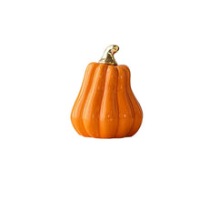 Load image into Gallery viewer, Glazed Ceramic Pumpkins by Allthingscurated spot a sculptural design that are perfect for adding a chic and stylish touch to your Halloween and Thanksgiving celebrations. Available in two designs in orange or white, let these ornamental pumpkins transform your home into a cozy autumn oasis. Featured here is the Tall Pumpkin in Orange.
