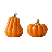 Load image into Gallery viewer, Glazed Ceramic Pumpkins by Allthingscurated spot a sculptural design that are perfect for adding a chic and stylish touch to your Halloween and Thanksgiving celebrations. Available in two designs in orange or white, let these ornamental pumpkins transform your home into a cozy autumn oasis. Featured here is the Orange Set consisting of a tall and short pumpkin.
