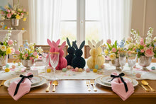 Load image into Gallery viewer, Easter-themed table setting with decorative bunnies and floral arrangements. This curated set of two Honeycomb Easter Bunnies by Allthingscurated instantly transforms any space into a festive Easter wonderland. Their adorable silhouettes add personality and warmth to your holiday décor. Quick assembly and compact storage, with proper care, they remain beautiful year after year. Comes in 5 delightful colors.
