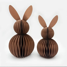 Load image into Gallery viewer, This curated set of two Honeycomb Easter Bunnies by Allthingscurated instantly transforms any space into a festive Easter wonderland. Their adorable silhouettes add personality and warmth to your holiday décor. Quick assembly and compact storage, with proper care, they remain beautiful year after year. Comes in 5 delightful colors. Seen here is a set of two brown bunnies on a white background.
