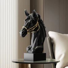 Load image into Gallery viewer, Black horse head sculpture with gold bridle on a table. Fargo Horse Head Bust by Allthingscurated is an elegant decorative sculpture with meticulous detail and flaunts a gorgeous gold-accented bridle. Perfect for horse enthusiasts and makes a meaningful gift for those born under the Horse zodiac sign. And expertly crafted to complement both timeless classic and contemporary modern interiors.
