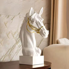 Load image into Gallery viewer, White horse head sculpture with gold bridle on a wood surface. Fargo Horse Head Bust by Allthingscurated is an elegant decorative sculpture with meticulous detail and flaunts a gorgeous gold-accented bridle. Perfect for horse enthusiasts and makes a meaningful gift for those born under the Horse zodiac sign. And expertly crafted to complement both timeless classic and contemporary modern interiors.
