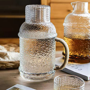 Kiv Hammered Glass Pitcher with Cover in 2 liter or 68 ounce capacity by Allthingscurated. Comes with a hemp rope handle for a rustic vibe. Large capacity and heat-resistant. It's the perfect thirst quencher for summer.