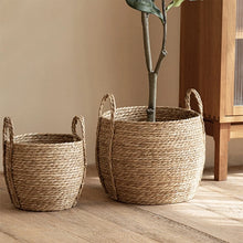 Load image into Gallery viewer, Leedon Woven Baskets by Allthingscurated are hand-woven from seagrass which is an eco-friendly material. The baskets feature sturdy handles for easy transportation and lend a rustic charm to any space. Perfect for storing household items or displaying your favorite plants. Available in 3 sizes.
