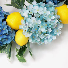Load image into Gallery viewer, Summer Lemon Hydrangea wreath by Allthingscurated features a vibrant and cheerful yellow and blue color scheme, evoking images of sunny blue skies and warm summer days. The wreath adds a pop of color to your door and bring a little extra happiness to your home.
