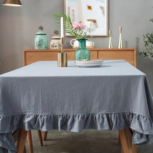 Introducing Ruffled Cotton Tablecloth by Allthingscurated. Made from 100% cotton, our tablecloth exudes French country charm with its romantic, frilly ruffles. With the perfect balance of decorative and laid-back, they have a welcoming and comforting vibe. Available in 8 solid colors. Featured here is the Light Gray tablecloth.