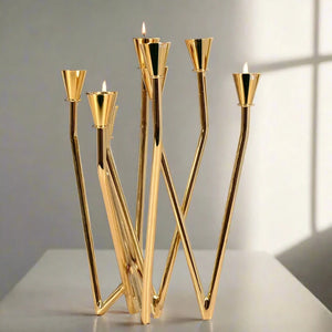 Lysa Gold Candelabra by Allthingscurated spots an asymmetrical design and clean lines that exude modern elegance. With 9 arms for taper candles, the gold-tone metal surface reflects the glow of the flames, creating a warm and captivating atmosphere. It’s stunning centerpiece for any occasion and decorative accent for any event or space.