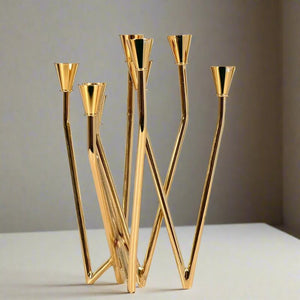 Lysa Gold Candelabra by Allthingscurated spots an asymmetrical design and clean lines that exude modern elegance. With 9 arms for taper candles, the gold-tone metal surface reflects the glow of the flames, creating a warm and captivating atmosphere. It’s stunning centerpiece for any occasion and decorative accent for any event or space.