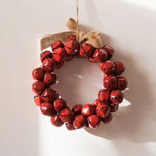 Load image into Gallery viewer, Christmas Jingle Bells Wreath by Allthingscurated comes in 3 semi-matte colors of Red, Multi Colors and Gold. The Multi Color Wreath features clusters of bell in green, red, ivory and brown. Each wreath is formed of bells made of iron entwined onto a jute rope and truly jingle with each movement. Measures approximately 18cm or 7 inches in width and height. This is a Red Wreath.
