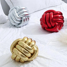 Load image into Gallery viewer, Metallic Color Knot Ball Cushions by Allthingscurated come in a metallic palette of Gold, Silver and Red. These cushions will give your home a trendy update easily with their bold design and bring attention to your favorite sofa or chair. Their unique spherical shape and eye-catching colors will add a stylish and sculptural touch to your living space.
