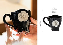 Load image into Gallery viewer, This Camellia Porcelain Cup Set / Mug by Allthingscurated features a single, significant bloom in a timeless black and white design that exudes sophistication. Its high fashion appeal makes it a perfect gift or impressive addition to your high-tea gatherings. Available as a mug or a cup set. Featured here is the Camellia Cup with Saucer set.
