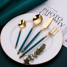 Load image into Gallery viewer, Neptune 4-piece Colored Handle Luxury Flatware Set by Allthingscurated beautifully blends mythical design with modern construction. Made from high-quality 18/10 stainless steel with a sleek mirror polishing for a modern look. Inspired by Poseidon’s Trident, the dinner fork is expertly shaped to resemble the 3-pronged spear. This place setting comes in Gold with either black, white, turquoise blue and green handle. Each set consists of a dinner spoon, dinner fork, dinner knife and a small spoon.
