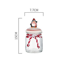 Load image into Gallery viewer, Christmas Festive Storage Jars by Allthingscurated are the perfect jars to keep all your festive treats fresh and delicious. The jars are airtight and each jar is topped with a ceramic lid decorated with a Santa Claus, Christmas Tree, Penguin, Gnome or Fox. Comes in 2 sizes with capacity of 300ml or 10 ounce and 1000ml or 34 ounce. Featured here is a small Penguin jar.
