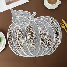 Load image into Gallery viewer, A white pumpkin-shaped lace placemat laid flat on a brown tabletop with dining props. Pumpkin Vinyl Placemats by Allthingscurated are designed with perforated hollow patterns to create a unique texture and add dimension to your table setting. Made from durable PVC vinyl, they are stain-resistant and easy to maintain. Perfect for Thanksgiving and Halloween celebrations. 
