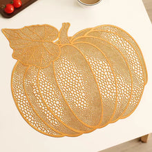 Load image into Gallery viewer, A pumpkin-shaped decorative placemat with an intricate openwork lace pattern, displayed on a white table surface. Pumpkin Vinyl Placemats by Allthingscurated are designed with perforated hollow patterns to create a unique texture and add dimension to your table setting. Made from durable PVC vinyl, they are stain-resistant and easy to maintain. Perfect for Thanksgiving and Halloween celebrations. 
