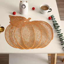 Load image into Gallery viewer, An orange pumpkin-shaped lace placemat set on a white table. Pumpkin Vinyl Placemats by Allthingscurated are designed with perforated hollow patterns to create a unique texture and add dimension to your table setting. Made from durable PVC vinyl, they are stain-resistant and easy to maintain. Perfect for Thanksgiving and Halloween celebrations. 
