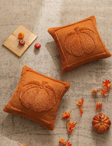 Two orange pumpkin-shaped cushions on a textured surface with decorative elements. Cozy living room with a sofa adorned with pumpkin-themed pillows and a yellow blanket. The Velour Pumpkin Cushion Cover by Allthingscurated is a beautiful way to bring the warmth of fall into your home. With its elegant tufted pumpkin design and soft velour fabric, it offers both comfort and style. Perfect for autumn and Thanksgiving, this decorative pillow adds a cozy, inviting touch to any space.