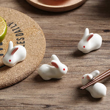 Load image into Gallery viewer, Enhance your Asian dining experience with our Ceramic Rabbit Chopstick Rests by Allthingscurated. These pieces will bring a playful edge to your table with their ability to keep your chopsticks clean and secure. Comes in a set of 3 or 6 pieces.
