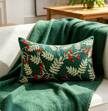 Load image into Gallery viewer, Rectangular dark green throw pillow with embroidered gold leaves and red berry clusters, resting on a dark green throw blanket for festive Christmas home decor.
