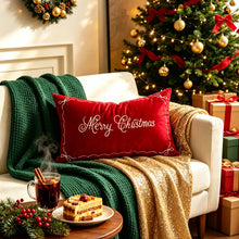 Load image into Gallery viewer, A white sofa styled with home decor ideas including a red Merry Christmas pillow, a green knit throw, and a gold sequined blanket, set beside a tree and a small table with a steaming mug and cake.
