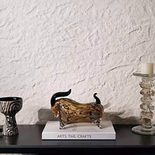 Load image into Gallery viewer, Decorative bull figurine on a book with a textured white wall background. Glass bull figurine on books with candles on a table against a textured wall. Rex Decorative Bull by Allthingscurated are meticulously handmade from high quality glass. Comes in three striking finishes—an all-all black edition or two-tone variants featuring bold graphic elements. Rex brings contemporary flair and bold energy to any room. More than décor, it’s an ideal gift for those born under the Ox zodiac and Taurus sign.
