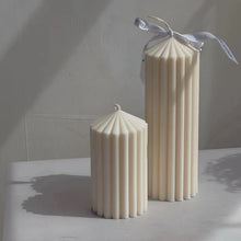 Load image into Gallery viewer, White Ribbed Column Candles by Allthingscurated are made of 100% soy wax. Hand crafted with vertical ridged pattern for texture, these candles are scented with the sweet smell of white rose. Available in 2 sizes.
