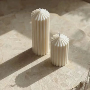 White Ribbed Column Candles by Allthingscurated are made of 100% soy wax. Hand crafted with vertical ridged pattern for texture, these candles are scented with the sweet smell of white rose. Available in 2 sizes.