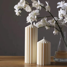 Load image into Gallery viewer, White Ribbed Column Candles by Allthingscurated are made of 100% soy wax. Hand crafted with vertical ridged pattern for texture, these candles are scented with the sweet smell of white rose. Available in 2 sizes.
