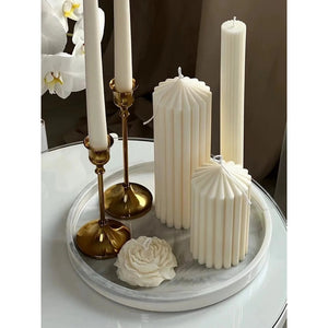 White Ribbed Column Candles by Allthingscurated are made of 100% soy wax. Hand crafted with vertical ridged pattern for texture, these candles are scented with the sweet smell of white rose. Available in 2 sizes.