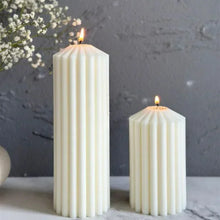 Load image into Gallery viewer, White Ribbed Column Candles by Allthingscurated are made of 100% soy wax. Hand crafted with vertical ridged pattern for texture, these candles are scented with the sweet smell of white rose. Available in 2 sizes.
