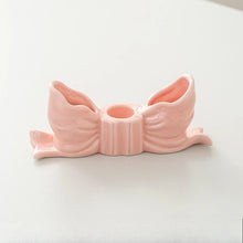 Load image into Gallery viewer, Fashion Bow Candle Holder by Allthingscurated spots a distinctive knot design, beautiful yet practical. Perfect for wedding celebrations, home styling, or to infuse warmth and romance into any living space. Available in three colors and 2 sizes. Shown here is a small size Pink bow candle holder on a white background.
