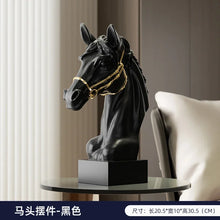 Load image into Gallery viewer, Black horse head sculpture with gold bridle on a round table with a neutral background. Fargo Horse Head Bust by Allthingscurated is an elegant decorative sculpture with meticulous detail and flaunts a gorgeous gold-accented bridle. Perfect for horse enthusiasts and makes a meaningful gift for those born under the Horse zodiac sign. And expertly crafted to complement both timeless classic and contemporary modern interiors.
