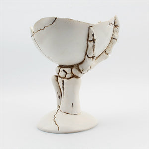 Gothic Skeleton Hand Storage Bowl by Allthingscurated  boasts a spooky design featuring a ghoulish skeleton claw in neutral warm off-white and vivid hand bones encircling the bowl. Perfect for adding a frightful touch to your Halloween decor. Crafted from resin and measuring height of 13.5m or5.3 inches and width of 12cm or 4.7 inches.